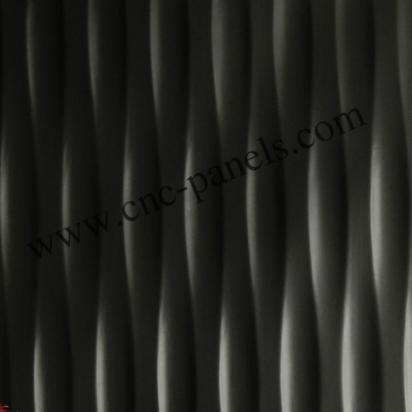 PAN 052 charcoal wave wall panel — deep vertical wave texture in matte graphite finish, shown with red flowers in white planter